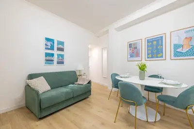 a living room with a green couch and a table at NOSTROMONDO-Elegant Suite with patio in Monti Parioli in Rome