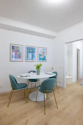 a white dining room with a table and chairs at NOSTROMONDO-Elegant Suite with patio in Monti Parioli in Rome