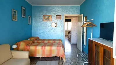 a blue bedroom with a bed and a couch at A casa di Ugo - Colors and space at Pigneto, Rome in Rome
