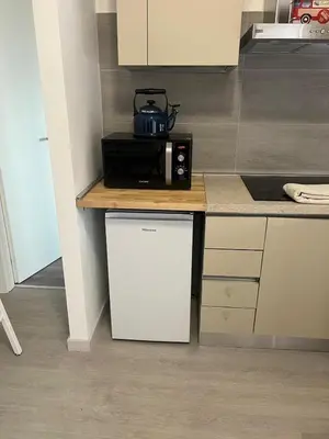a kitchen with a white refrigerator and a microwave at Primavalle Lodge - METRO Battistini in Rome