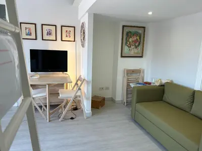 a living room with a couch and a desk with a television at Primavalle Lodge - METRO Battistini in Rome