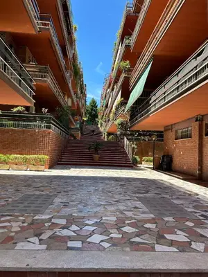 an empty courtyard of an apartment building with stairs at Primavalle Lodge - METRO Battistini in Rome
