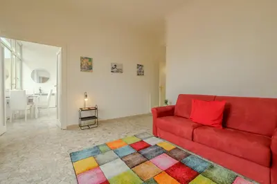 a living room with a red couch and a colorful rug at Operetta View Apartment in Rome
