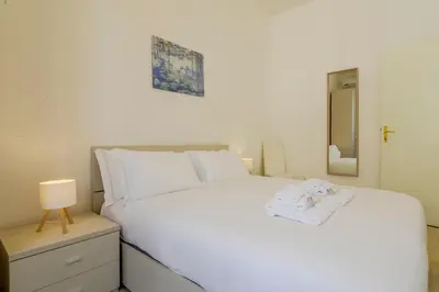 a bedroom with a large white bed with towels on it at Operetta View Apartment in Rome