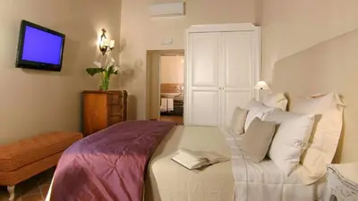 a bedroom with a white bed and a tv at Respighi Apartments - Rome City Center in Rome