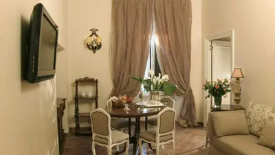 a living room with a table and chairs and a television at Respighi Apartments - Rome City Center in Rome