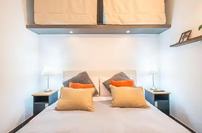 a bedroom with a large bed with orange pillows at Battistini Pretty Apartment in Rome