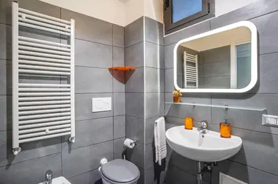 a bathroom with a sink and a toilet and a mirror at Battistini Pretty Apartment in Rome