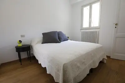 a bed in a white room with a window at Colosseum Panoramic Terrace in Rome