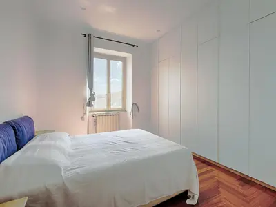 a white bedroom with a bed and a window at Vittorio Panoramic Apartment in Rome