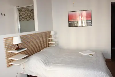a white bedroom with a bed and a mirror at B&B Mazzini in Rome
