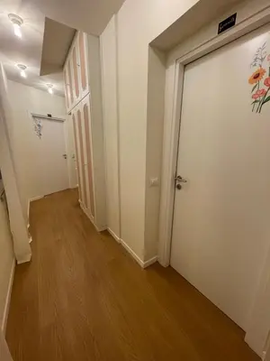 an empty hallway with a door and wooden floors at Flowers Rooms - Ponte Milvio in Rome