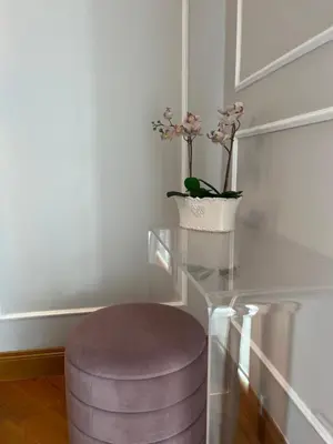 a glass table with a stool and a vase with flowers at Luxury House Alessia in Rome
