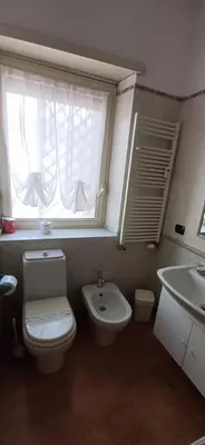 a bathroom with a toilet and a sink and a window at Lively House in Rome