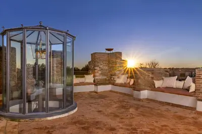 a glass gazebo on a patio with the sunset at Dimora della Luna in Rome