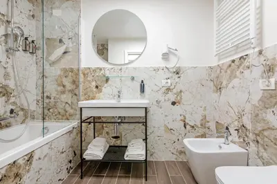 a bathroom with a sink and a tub and a mirror at Dei Greci Guesthouse in Rome
