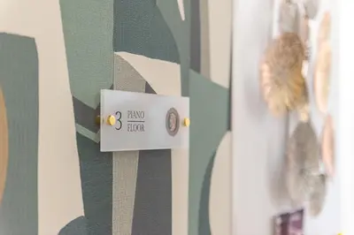 a lightswitch on a wall with green and white stripes at Maison dei Greci in Rome