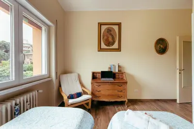 a bedroom with a bed and a chair and a dresser at Eleganza e Arte a Città Giardino 5' Metro B in Rome