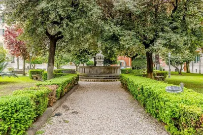 a park with a fountain and trees and bushes at Wonderful Garden at Colosseo in Rome