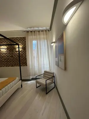 a bedroom with a bed and a chair and a window at Home Domus Castel Sant'Angelo in Rome