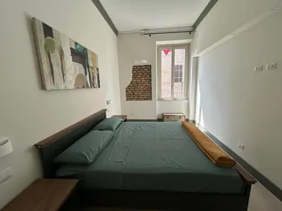 a bedroom with a green bed in a room at Home Domus Castel Sant'Angelo in Rome