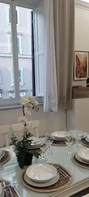 a dining room table with white plates and glasses at MURA DI PRATI - Spazioso appartamento per 8 a San Pietro in Rome