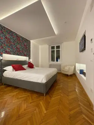 a bedroom with a large bed and wooden floors at carpe diem sistina in Rome