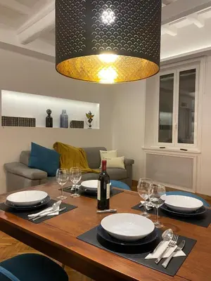 a dining room table with a bottle of wine and glasses at carpe diem sistina in Rome