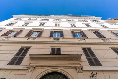 a tall white building with windows on top of it at Spanish Steps Oasis Suite in Rome