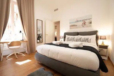 a bedroom with a large bed and a desk at Valenziani Luxury Central Rome in Rome