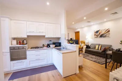 a kitchen with white cabinets and a living room at Valenziani Luxury Central Rome in Rome