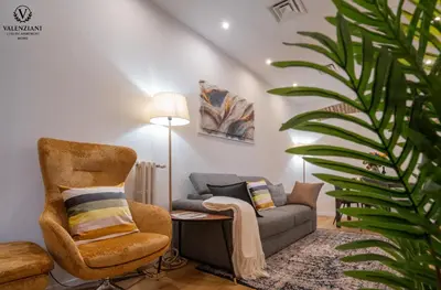 a living room with a chair and a couch at Valenziani Luxury Central Rome in Rome