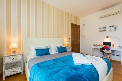 a bedroom with a large bed with blue sheets at Boutique Domus Trastevere Family in Rome