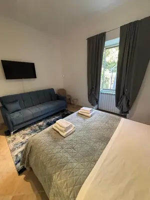 a bedroom with a bed and a blue couch at Pigneto Cosmo House in Rome