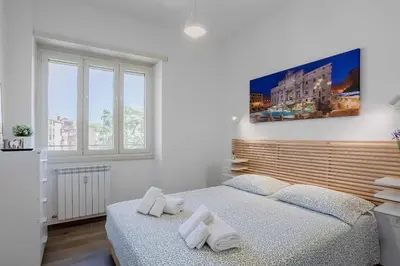 a white bedroom with two towels on a bed at Your dream in Rome San Paolo in Rome