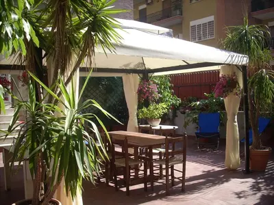 a table and chairs under a white umbrella at Casa Marino Roma in Rome