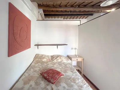 a bedroom with a bed with a red pillow on it at Attic Castel Sant'Angelo - Pantheon in Rome