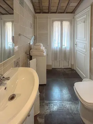 a white bathroom with a sink and a toilet at Attic Castel Sant'Angelo - Pantheon in Rome