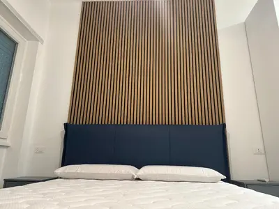 a bed with a blue headboard in a room at Star Suite Rome in Rome