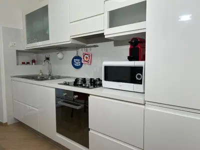 a white kitchen with a microwave and a stove at Cris House Monteverde in Rome