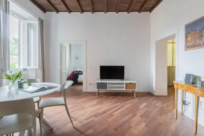 a living room with a table and a tv at Fienaroli in Trastevere in Rome