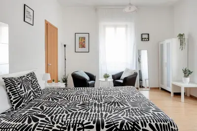 a bedroom with a black and white bed and chairs at Studio basic nice&comfortable in Rome