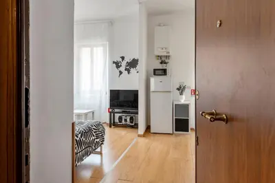 a living room with a door and a room with a television at Studio basic nice&comfortable in Rome
