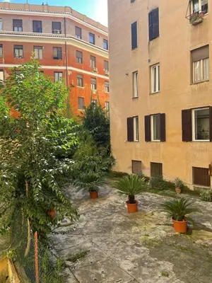 a courtyard with plants in front of buildings at Celio west side apartment in Rome