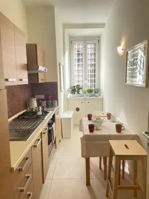 a kitchen with a small table and a kitchen with a stove at Celio west side apartment in Rome