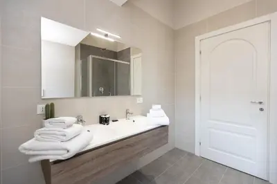 a white bathroom with a sink and a mirror at Amazing Colosseo in Rome