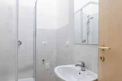 a white bathroom with a sink and a shower at Boccanera a Trastevere Holiday Apartment in Rome