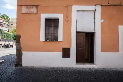 an orange and white building with a window and a door at Boccanera a Trastevere Holiday Apartment in Rome