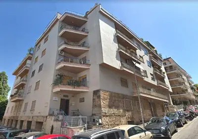 a large building with cars parked in front of it at Saint Peter's House in Rome