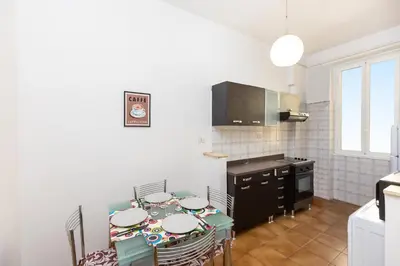 a kitchen with a table with chairs and a stove at Jenner Apartment by Rental in Rome in Rome